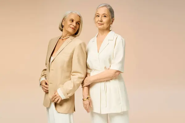 Two mature women radiate joy and style while sharing a moment filled with affection and elegance. — Stock Photo