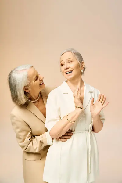Two fashionable mature women share a playful and affectionate moment, showcasing their love. — Stock Photo