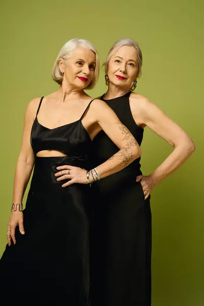 Two mature women showcase their romance and fashion sense against a lively backdrop. — Stock Photo