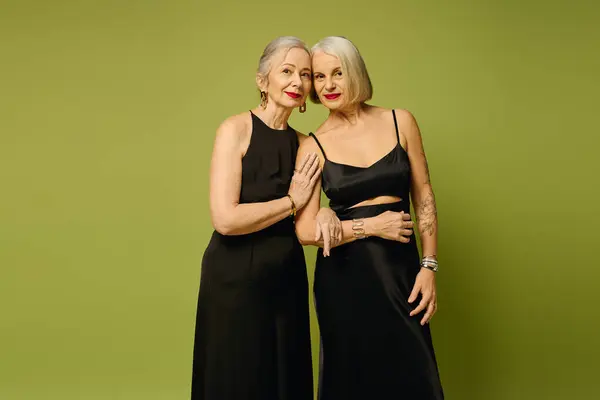 Two fashionable women share a loving moment, showcasing their elegant outfits and deep connection. — Stock Photo