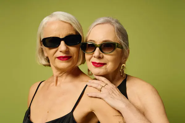 Two fashionable women exude charm and affection with stylish sunglasses and bold red lips. — Stock Photo