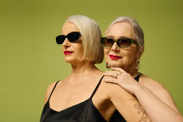 Two stylish mature women express their romantic connection while wearing chic outfits. — Stock Photo