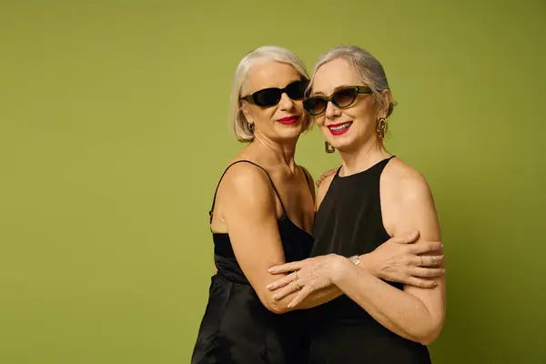 Two stylish women share a loving moment, radiating confidence in trendy outfits. — Stock Photo