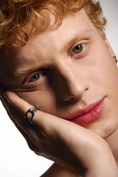 A handsome young man strikes a fashionable pose with a thoughtful expression in a well lit studio. — Stock Photo