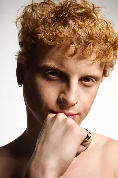 A stylish young man confidently poses thoughtfully against a simple backdrop. — Stock Photo