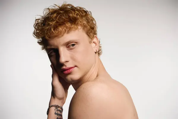 A stylish young man poses confidently, showcasing his trendy look against a simple backdrop. — Stock Photo