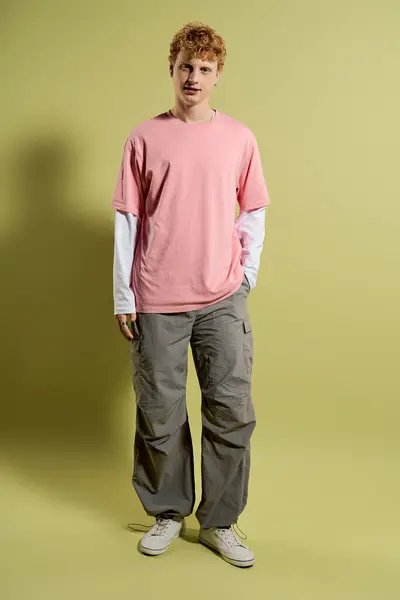 A young, handsome man stands confidently in a trendy outfit, showcasing his stylish vibe. — Stock Photo