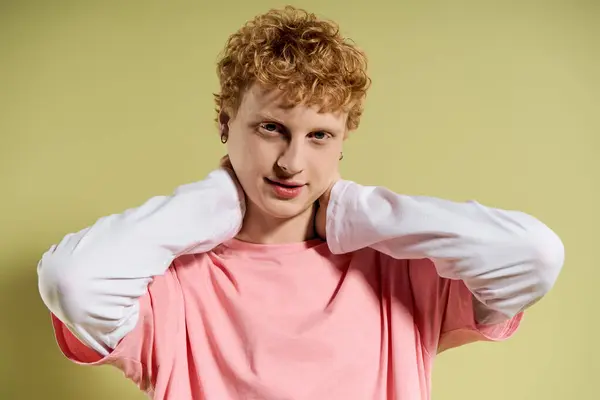 A young man exudes confidence in a stylish outfit, striking a fun pose with a cheerful expression. — Stock Photo