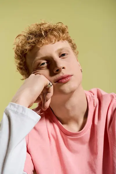A fashionable young man rests his chin on his hand, exuding confidence with a trendy look. — Stock Photo