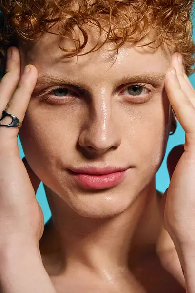 Young man exudes confidence while striking a fashionable pose with expressive hands on his face. — Stock Photo