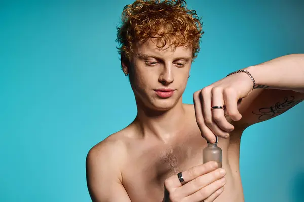 A trendy young man uses a skincare product, showcasing his fashionable style and confidence. — Stock Photo