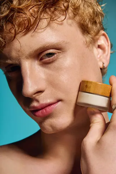 Trendy giovane uomo mette in evidenza una routine di cura della pelle, trasudando stile mentre tiene un vaso. — Foto stock