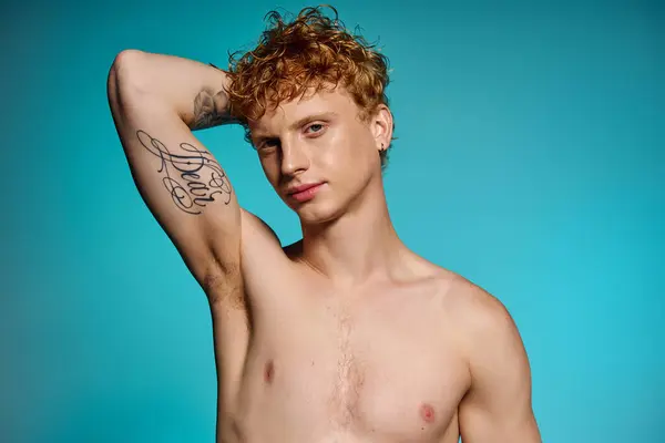 A stylish young man with great hair and a bold tattoo exudes confidence. — Stock Photo