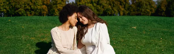 Two stylish women share a moment of joy in a vibrant park, basking in the spring sunshine. — Stock Photo