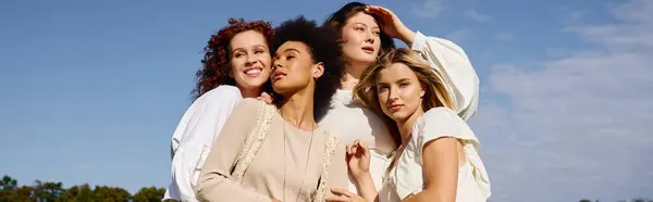 Four stylish women pose outdoors, confidently showcasing their unique spring looks. — Stock Photo