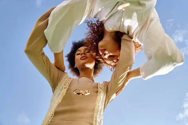 Two stylish females showcase their confidence under a clear blue sky in a park. — Stock Photo