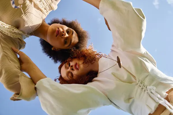 Under a bright blue sky, two fashionable friends share a moment of confidence and style outdoors. — Stock Photo