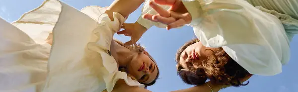 Two fashionable women express their confidence under a brilliant blue sky surrounded by nature. — Stock Photo