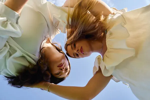 Two stylish women connect with each other in a fresh spring setting, radiating confidence and grace. — Stock Photo