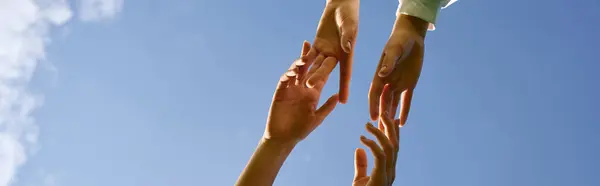 Two pairs of hands extending toward one another, symbolizing connection and support in nature. — Stock Photo