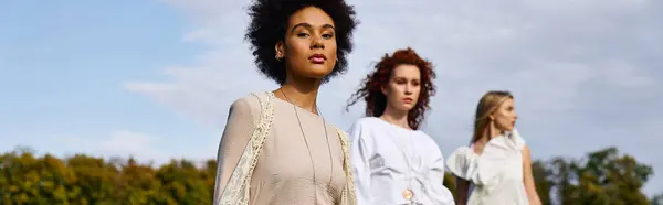 Fashionable women exude confidence while strolling through a lively spring park, embracing nature. — Stock Photo