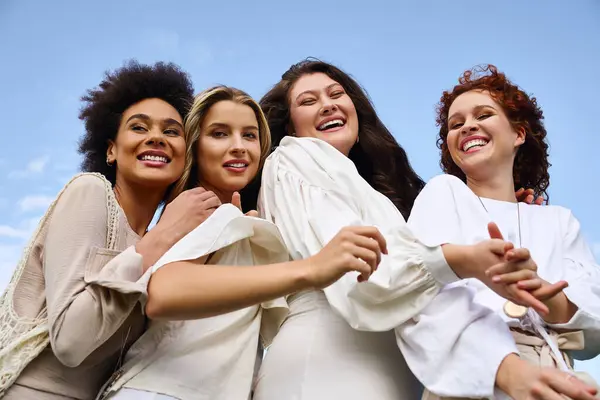 A group of four fashionable friends joyfully enjoying a sunny spring day in a picturesque park. — Stock Photo