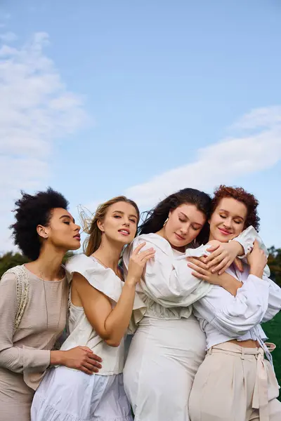 Four stylish women enjoy a joyful spring day in a sunlit park, exuding confidence. — Stock Photo