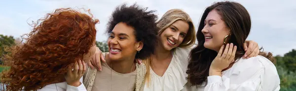Four stylish women share a joyful moment in a blooming park, exuding confidence and beauty. — Stock Photo