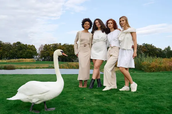Four stylish friends exude confidence in chic outfits as they embrace the beauty of spring outdoors. — Stock Photo