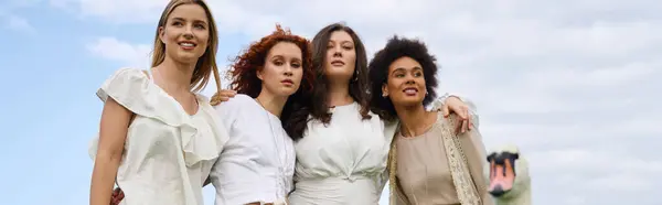 Four fashionable women express confidence while enjoying a sunny spring day in the park. — Stock Photo