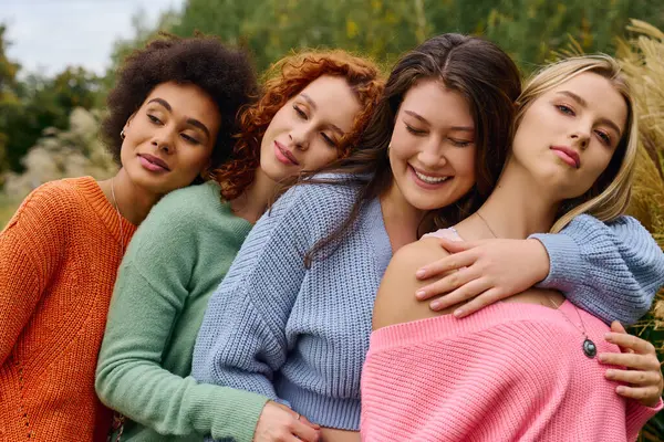 Quatre femmes à la mode rayonnent de confiance tout en riant ensemble à l'extérieur au printemps. — Photo de stock