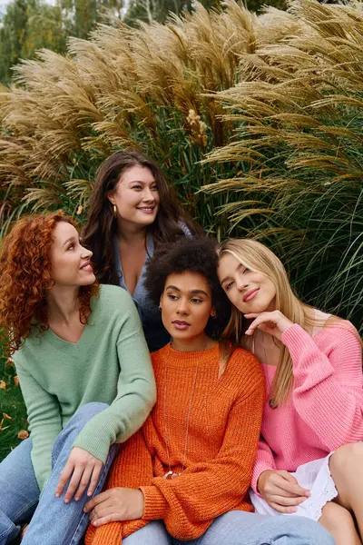 A group of fashionable young women exudes confidence as they relax together outside in springtime. — Stock Photo