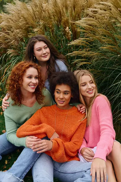 Four stylish women enjoy a sunny spring day in a lush park surrounded by nature. — Stock Photo