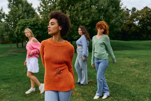 Groupe de femmes élégantes profitant d'une journée de printemps en plein air dynamique dans le parc, rayonnant de confiance. — Photo de stock