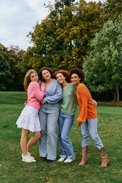 Four stylish friends hug in a park, radiating confidence and joy this spring. — Stock Photo