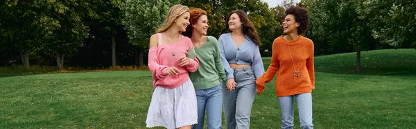 Four friends shine in chic spring outfits, enjoying a sunny day at the park. — Stock Photo