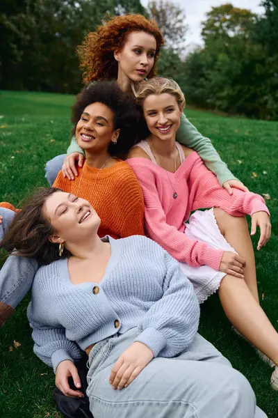 Four stylish women gather outdoors in a lush park, exuding confidence and camaraderie this spring. — Stock Photo