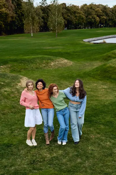 Four fashionable friends embrace nature while showcasing their vibrant spring outfits outdoors. — Stock Photo