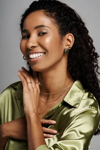 A beautiful woman with curly hair displays her dazzling jewellery while wearing stylish clothing. — Stock Photo