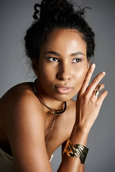 A graceful African American woman showcases fashionable jewelry with elegance and confidence. — Stock Photo