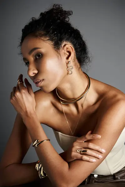 Captivating woman adorned in chic jewelry poses gracefully, highlighting her fashion forward style. — Stock Photo