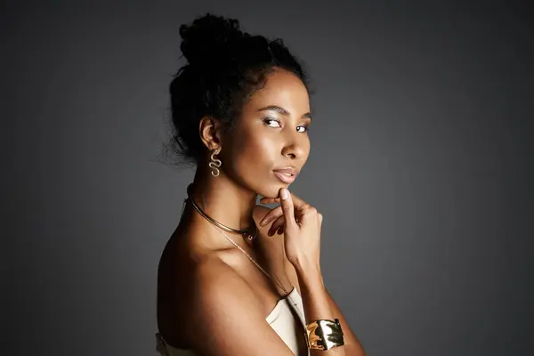 A confident woman showcases her fashion sense with exquisite jewellery and a graceful pose. — Stock Photo