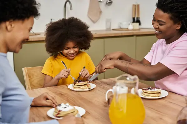 A loving family enjoys a delightful breakfast, sharing laughter and pancakes together. — Stock Photo