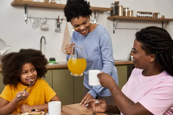 A vibrant family enjoys a cheerful breakfast, sharing laughter and nourishing moments together. — Stock Photo