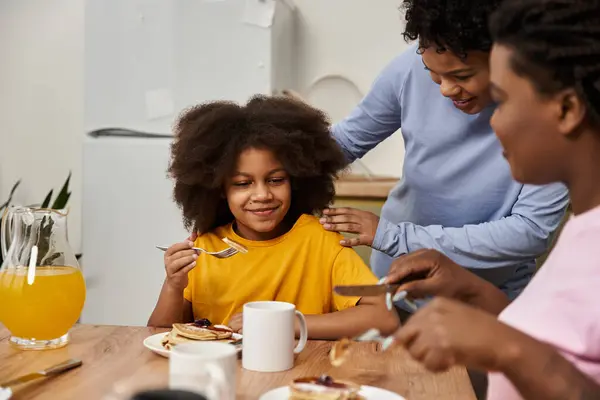 An LGBT family shares a joyful breakfast with their daughter, smiling together at the table. — Stock Photo