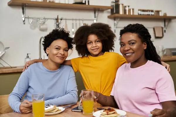 Heartwarming morning gathering at a cafe as a loving family enjoys pancakes and drinks together. — Stock Photo