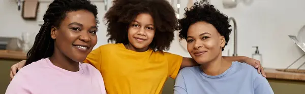 Two loving parents smile with their daughter, celebrating togetherness in a cozy space. — Stock Photo