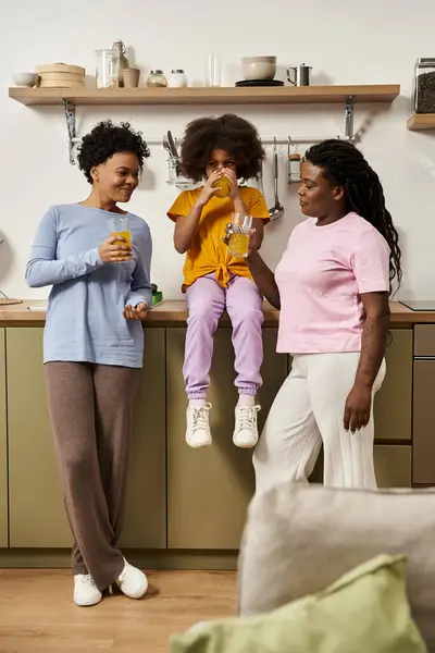 A cheerful family enjoys quality time together while sharing drinks in their modern kitchen. — Stock Photo