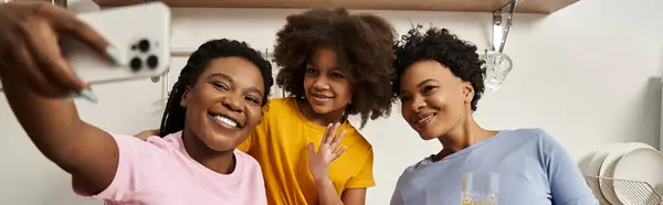 A diverse family enjoys a heartfelt selfie moment celebrating their bond in a warm kitchen. — Stock Photo