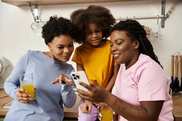 Two loving parents share a delightful moment with their daughter in a warm kitchen, enjoying drinks. — Stock Photo